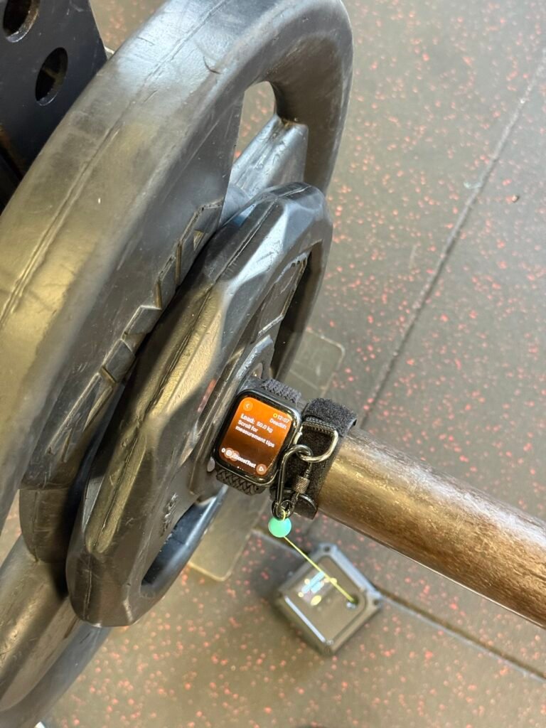 Apple Watch montato sulla barra accanto all'encoder durante un test sul campo. Apple Watch fissato a una barra durante un test sul campo con un encoder lineare